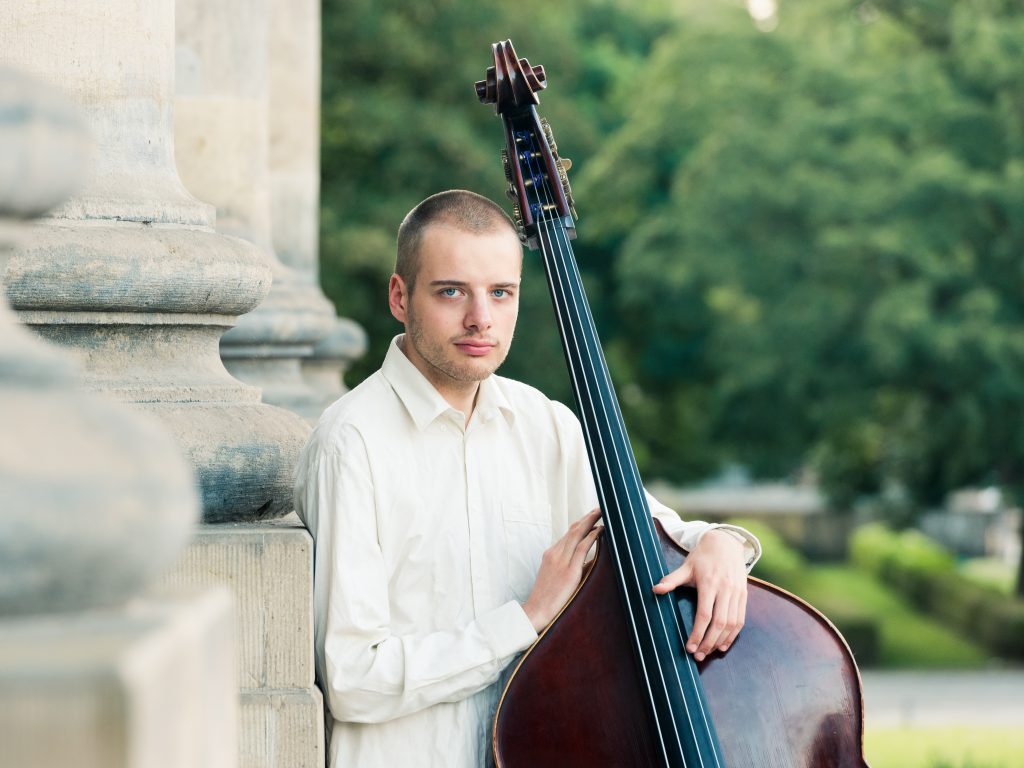 Businessportrait eines Musikers an einer Steinsäuler, hochwertiges Portrait durch einen Fotografen aus Leipzig